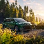 A green 2022 Toyota Sienna is shown parked near a hiking trail.