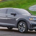A grey 2022 Volkswagen Atlas Cross Sport V6 SEL Premium R-Line is shown from the side parked in front of a grass hill.