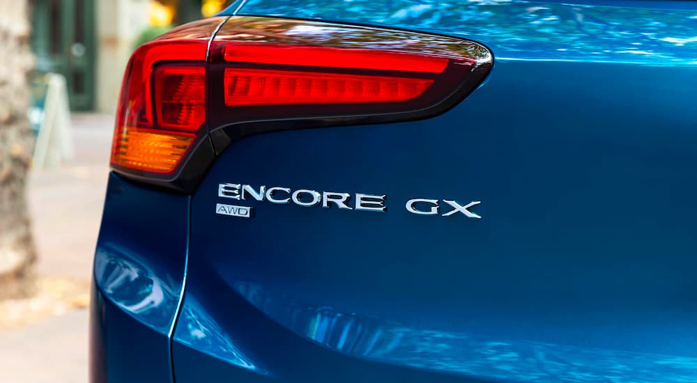 A close up shows the trunk badging and driver side taillight on a blue 2023 Buick Encore GX.