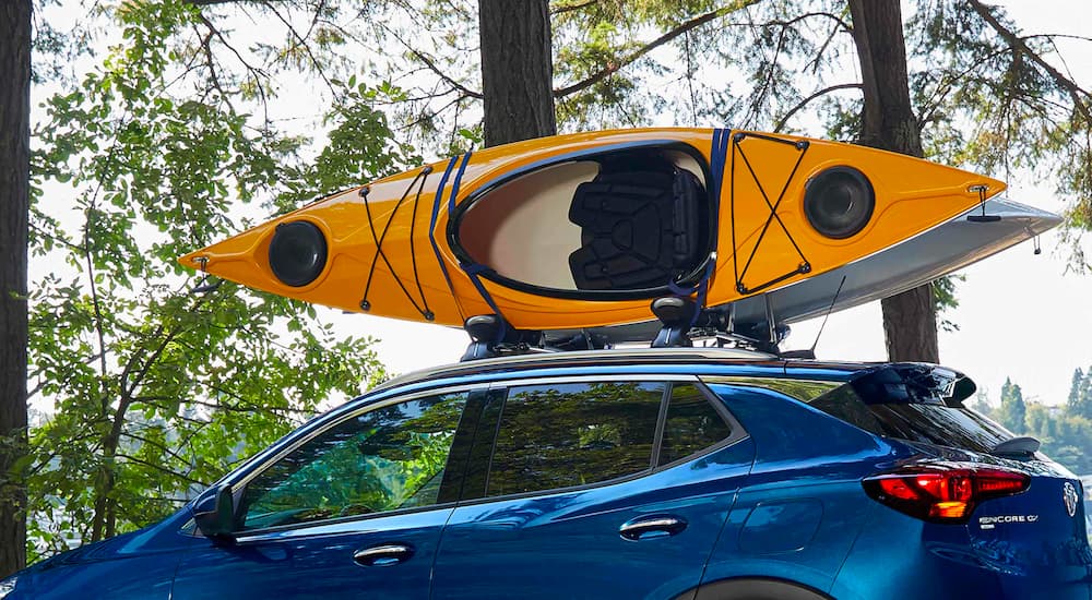 A close up shows kayaks on the roof of a blue 2023 Buick Encore GX.