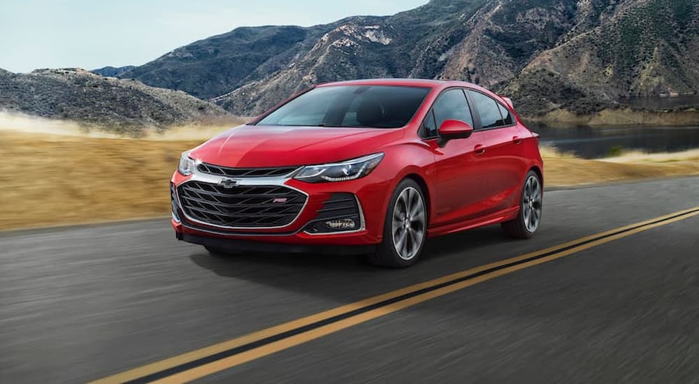 A red 2019 Chevy Cruze is shown driving on an empty highway.