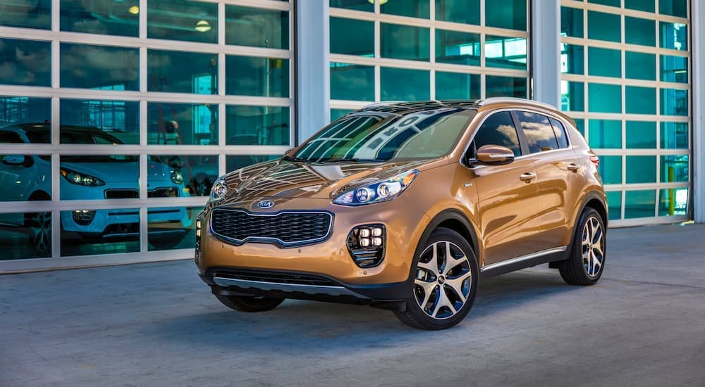 A yellow 2019 Kia Sportage is shown from the side after leaving a Certified Pre-Owned Kia dealer.
