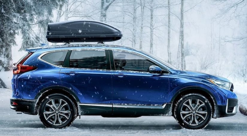 A popular Certified Pre-Owned car, a blue 2020 Honda CR-V Touring is shown from the side parked in the snow.