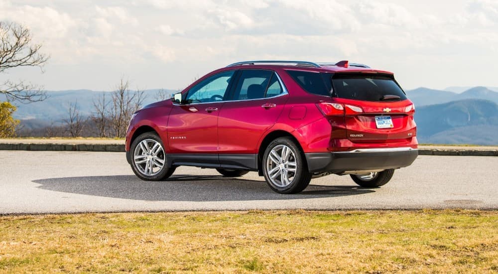 A red 2020 Chevy Equinox is shown from the side parked with a view of a mountain.