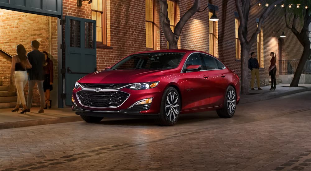 A red 2022 Chevy Malibu is shown parked outside a restaurant.