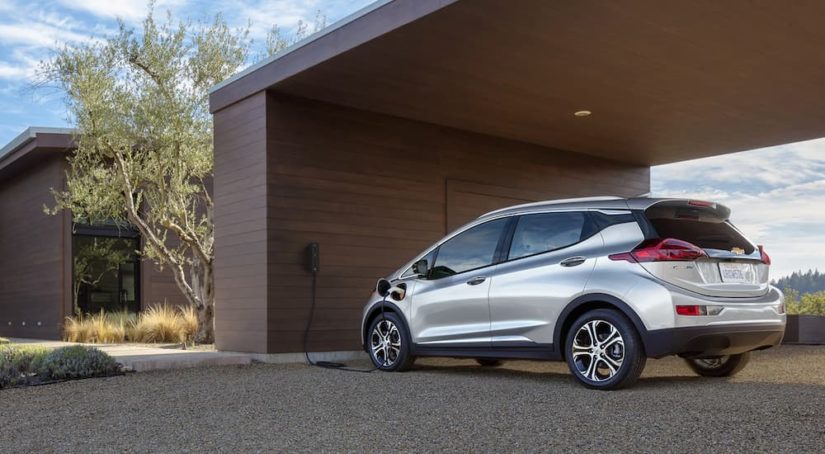 A silver 2021 Chevy Bolt EV is shown at a charging station.