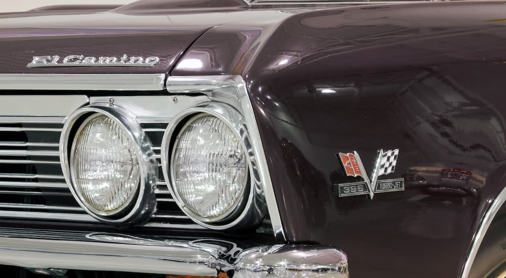 A close up shows the headlight on a purple 1967 Chevy El Camino SS.
