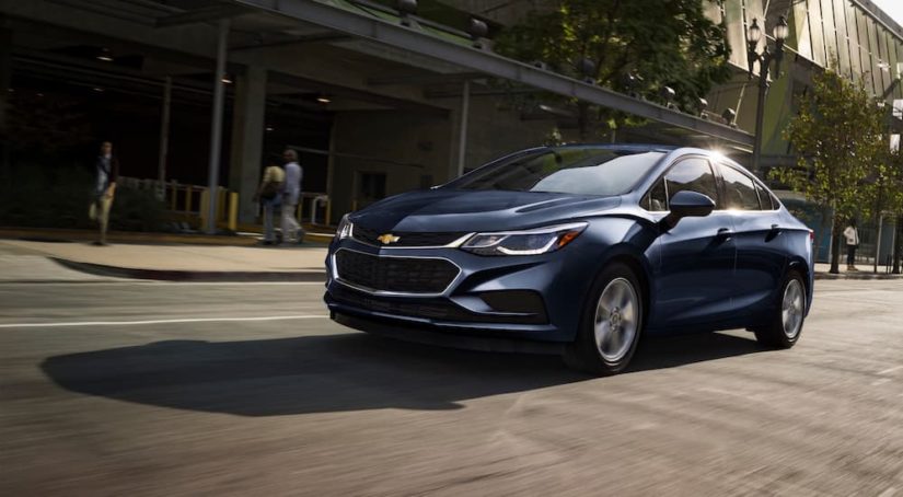 A dark blue 2018 Chevy Cruze is shown on a city street after visiting a Chevy dealer.