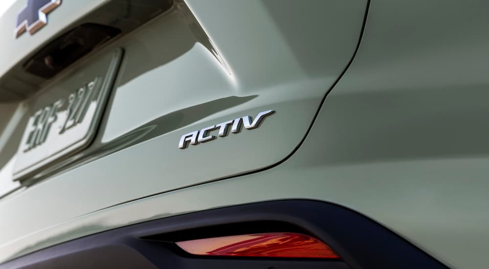 A close up shows the Activ badge on the trunk of a light green 2024 Chevy Trax Activ.