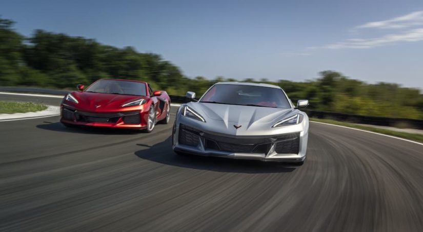 A red and a silver 2023 Chevy Corvette Z06 are shown on a race track.