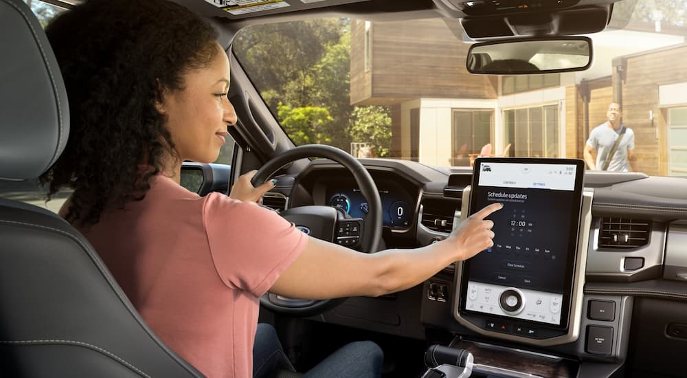 A woman is shown using the infotainment screen in a 2022 Ford F-150 Lightning after leaving a Ford dealer.
