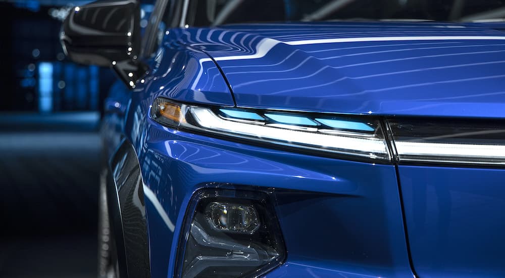 A close up shows the passenger side headlight on a blue 2024 Chevy Silverado EV RST.