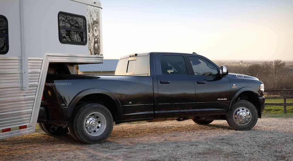 A black 2022 Ram 3500 is shown towing a trailer after leaving a Ram 3500 dealership.