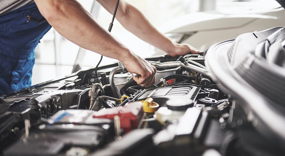 A mechanic is shown working on car after someone searched how to 'sell your car.'