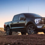 A black 2021 Ford F-150 Lariat is shown parked on trail during a sunset.