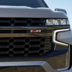 A close up shows the grille and headlight of a grey 2022 Chevy Suburban Z71.
