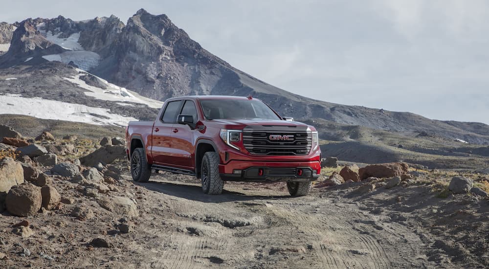 A red 2022 GMC Sierra 1500 AT4X is shown from the front on a dirt trail.