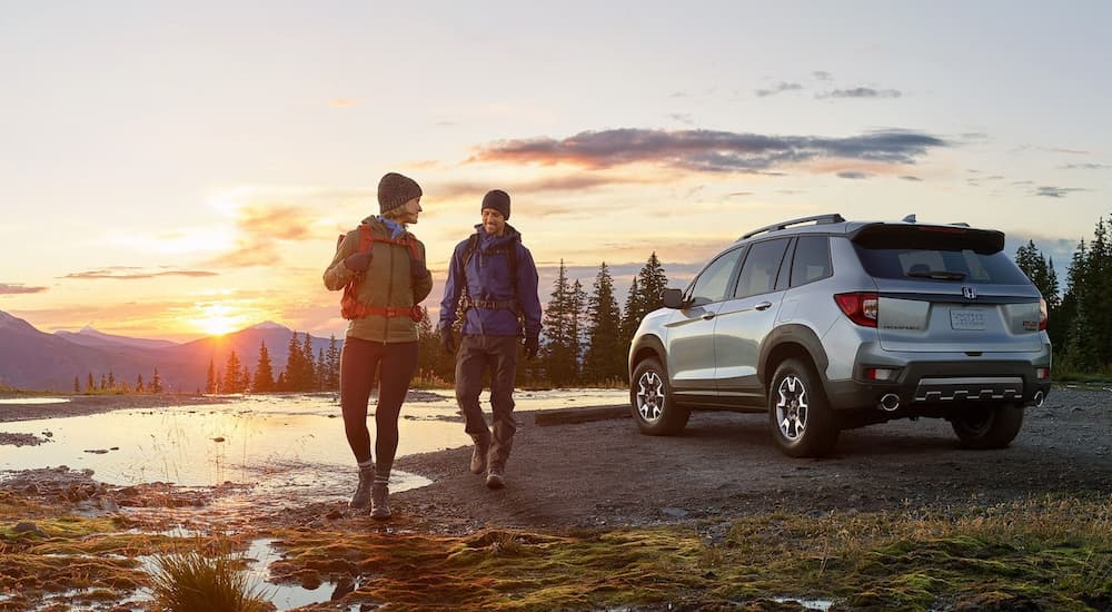 A silver 2022 Honda Passport Trailsport is shown from the rear parked near a body of water.