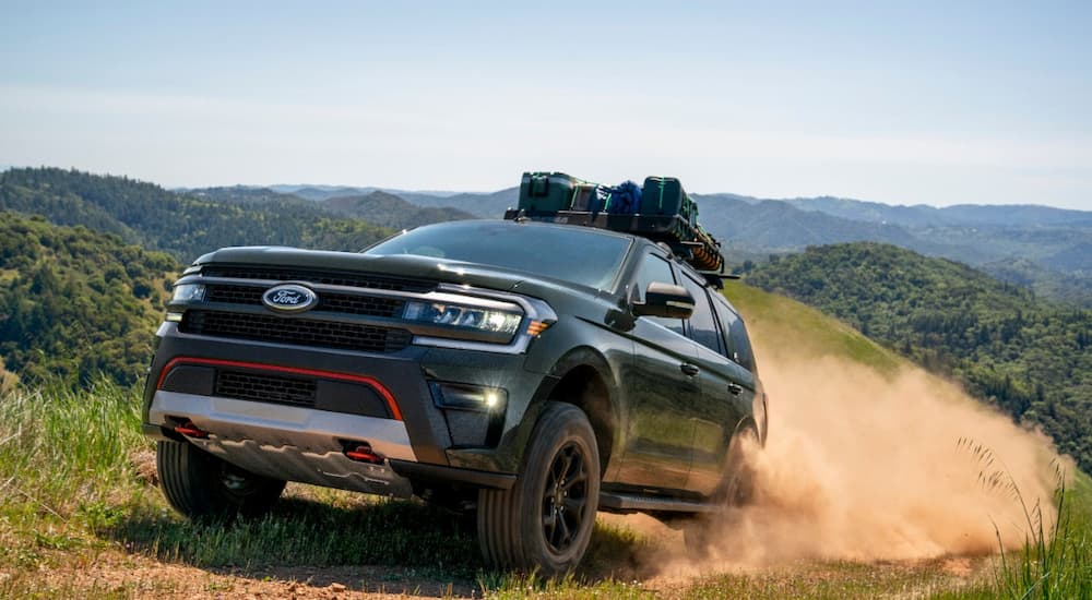 A green 2022 Ford Expedition Timberline is shown driving on a dusty trail.