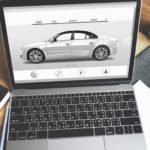 A white vehicle is shown on a laptop screen for a build-to-order Ford dealership.