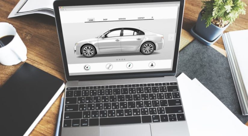 A white vehicle is shown on a laptop screen for a build-to-order Ford dealership.