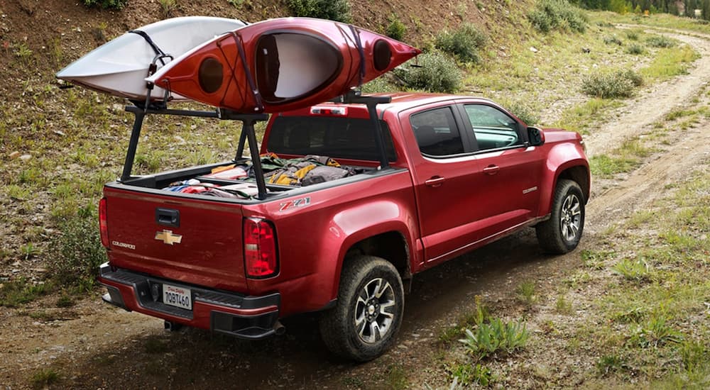 A red 2020 Chevy Colorado Z71 is shown from a rear angle driving on a trail.