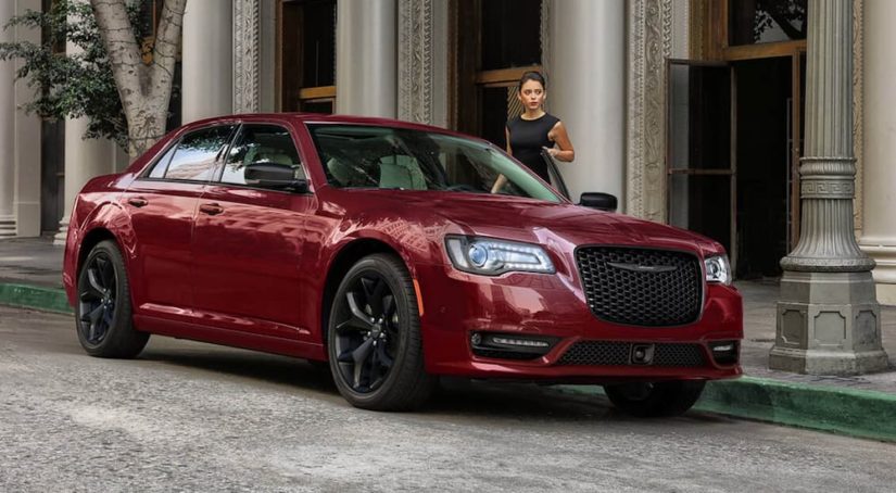 A red 2021 certified pre-owned Chrysler 300 Touring L is shown parked on the side of a city street.