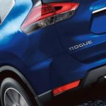 A close up shows the rear tire and bumper of a blue 2020 Nissan Rogue.