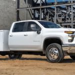 A white 2022 Chevy Silverado 3500HD Chassis Cab is shown parked at a construction site after leaving a commercial truck dealer.