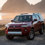 A red 2022 Toyota 4Runner TRD is shown parked near a body of water after researching 'how to sell your car.'