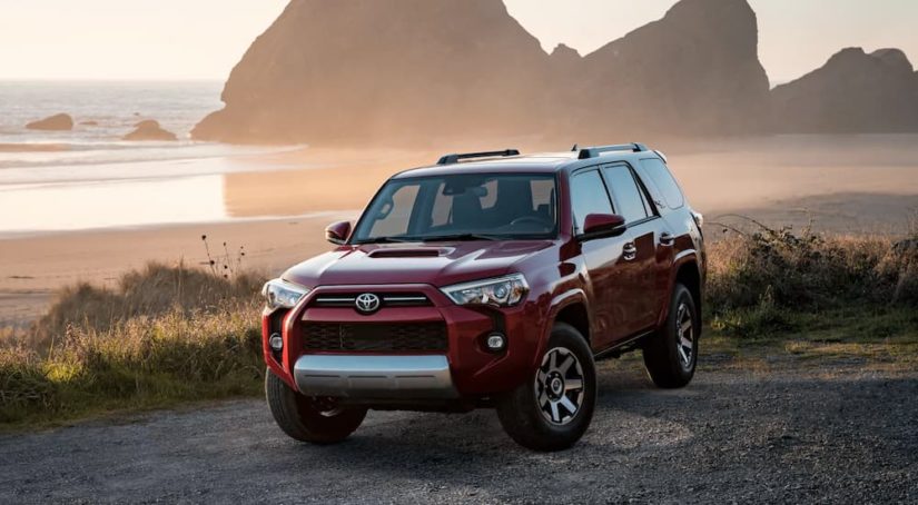 A red 2022 Toyota 4Runner TRD is shown parked near a body of water after researching 'how to sell your car.'