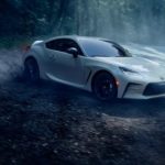A white 2022 Toyota GR86 is shown driving on a foggy forest road.