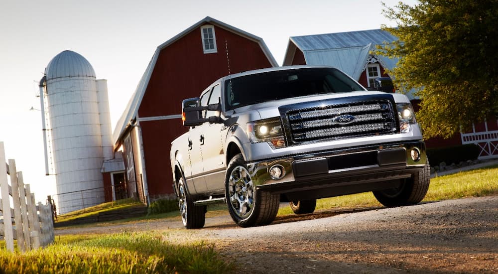 A white 2014 Ford F-150 Lariat is shown parked at a farm.