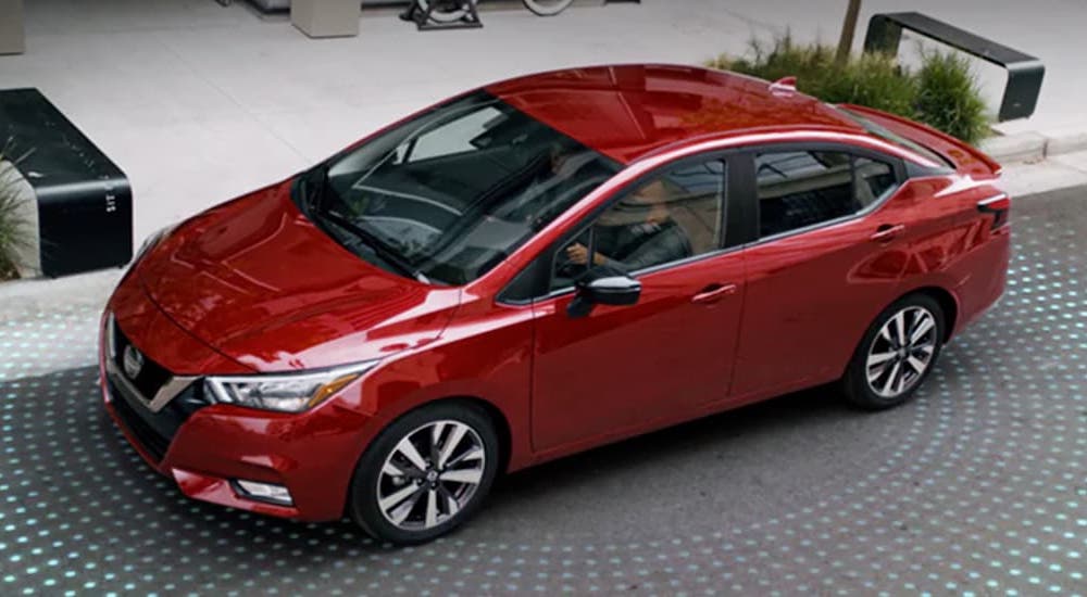 A red 2022 Nissan Versa is shown from a high angle with simulated sensors shown around it.