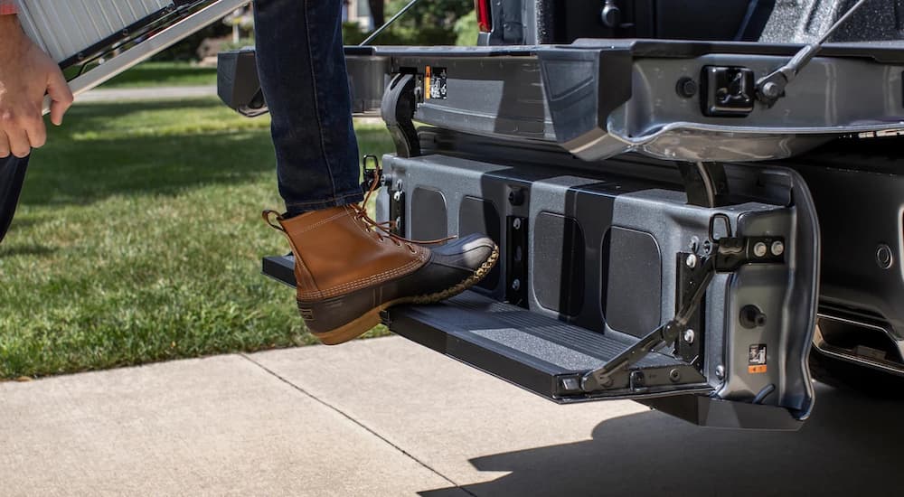 A person is shown stepping onto the Multi-Flex Tailgate on a silver 2022 Chevy Silverado 1500 Limited.