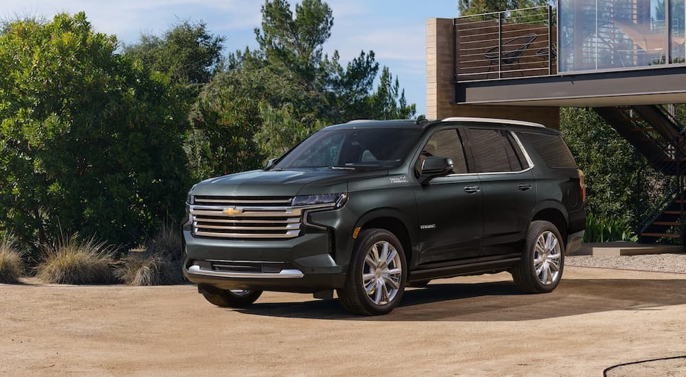 A green 2022 Chevy Tahoe High Country is shown parked in a driveway.