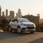 A silver 2022 Chevy Trax is shown parked on top of a city hill.