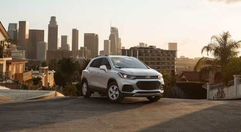 A silver 2022 Chevy Trax is shown parked on top of a city hill.