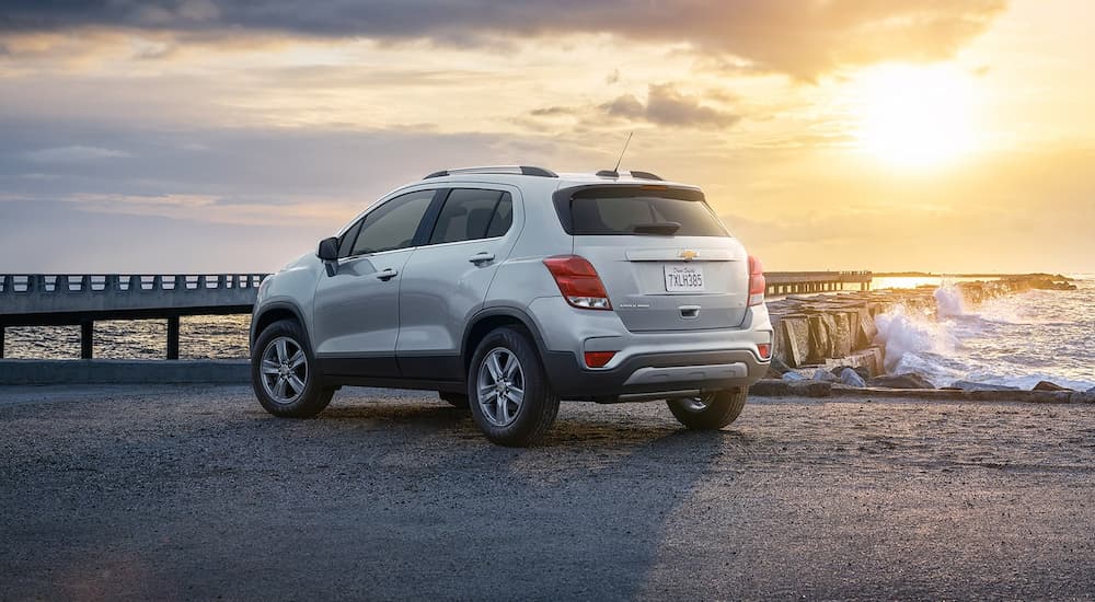 A silver 2022 Chevy Trax is shown from a rear angle parked near the ocean.