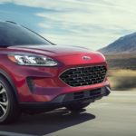 A red 2022 Ford Escape SE Sport is shown driving on a desert highway.