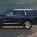 A black 2022 GMC Yukon XL is shown from the side parked on a of a mountain trail.