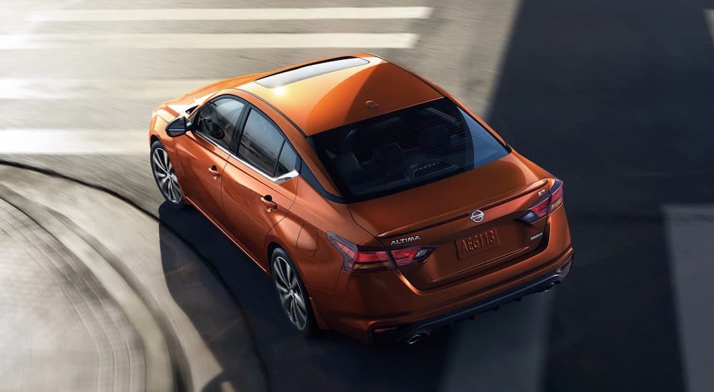 An orange 2022 Nissan Altima is shown from a high angle turning on a city street.