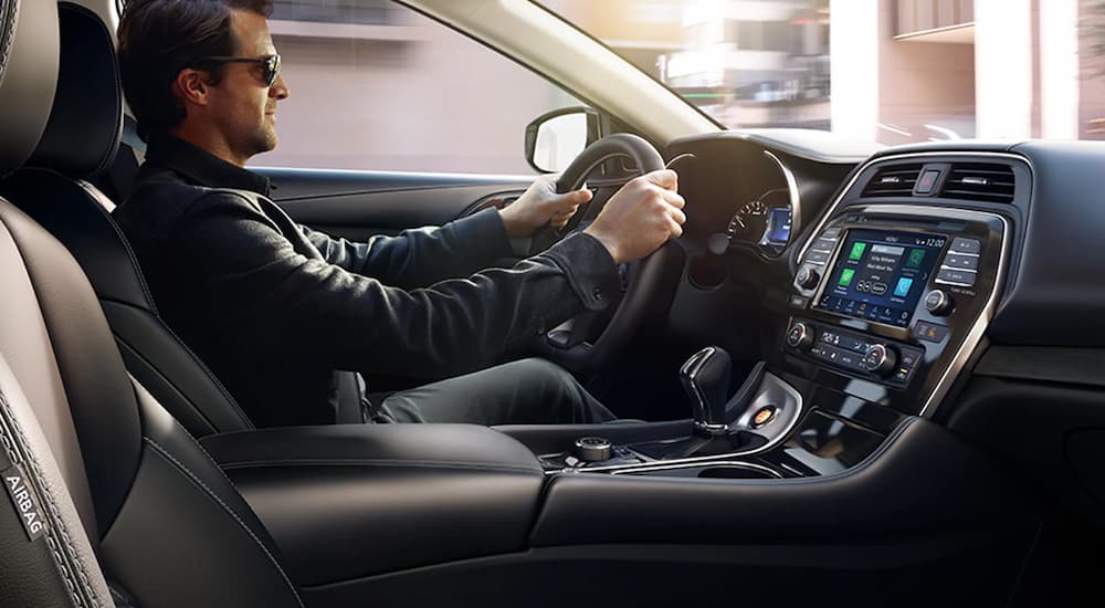 A man is shown driving a 2022 Nissan Maxima.