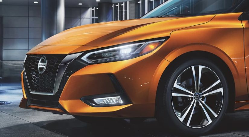 A close up of the front grille and headlight on an orange 2022 Nissan Sentra is shown.