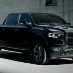 A black 2022 Ram 1500 is shown from the front at an angle parked in front of a concrete building after searching "CDJR dealer near me."