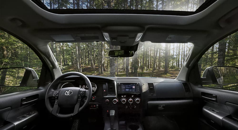 The black interior of a 2022 Toyota Sequoia TRD Pro shows the steering wheel and infotainment center.