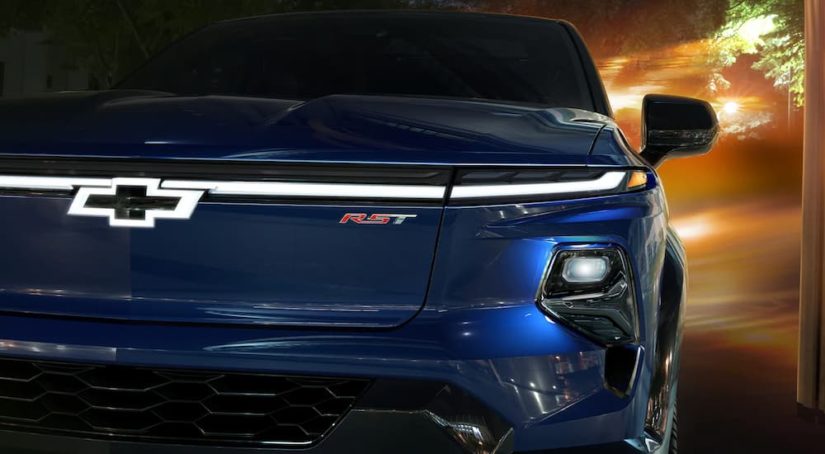 A close up of the front of a blue 2024 Chevy Silverado EV is shown during a 2024 Chevy Silverado EV vs 2022 Ford F-150 Lightning competition.