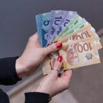 A set of hands is shown with a fan of currency.