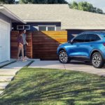 A blue 2022 Ford Escape 2022 Ford Escape vs 2022 Honda CR-V comparison.. shown in fron of a house from the rear at an angle after being involved in a