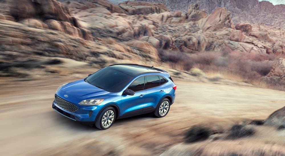 A blue 2022 Ford Escape Hybrid is shown from a high angle on a dirt path.